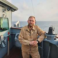 Ein Soldat steht auf dem Deck eines Schiffes