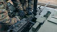 Soldaten laden ein schweres Maschinengewehr M2 QCB