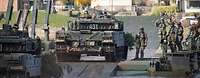 Mehrere Kampfpanzer vom Typ Leopard A7 befahren eine Schnellschwimmbrücke