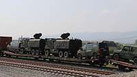 Bundeswehrfahrzeuge sind auf Eisenbahnwaggons geladen 