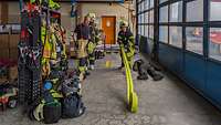 Ein Mädchen in Feuerwehr-Schutzkleidung rollt in einer Halle einen Schlauch aus.