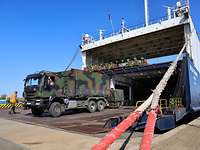 Auf eine Fähre werden Fahrzeuge der Bundeswehr verladen. 