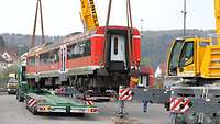 Ein Waggon wird mit 2 Autokränen auf einen Schwerlasttransport gehoben