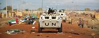 Transportpanzer der UN-Mission auf einer verwüsteten Straße mit herumliegendem Müll