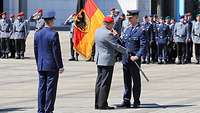 Ein Soldat übergibt einem anderen Soldaten eine Fahne