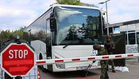 Heimatschützer sichern Kasernezufahrt Ein Soldat hält einen Spiegel unter einen weißen Bus