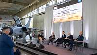 Ein Soldat stellt einer Expertenrunde auf einem Panel eine Frage.