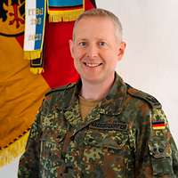 Portrait eines Soldaten vor einer Flagge