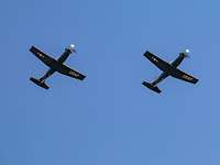Zwei Propellerflugzeuge von unten vor einem blauen Himmel fotografiert.