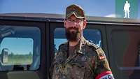 Ein Soldat steht vor einem militärischen Fahrzeug