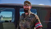 Ein Soldat steht vor einem militärischen Fahrzeug