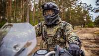 Ein Soldat sitzt auf dem geländegängigen Motorrad