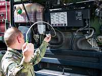 Ein Soldat prüft den Ölstand eines Lkw