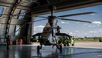 Ein Hubschrauber steht in einem Hangar.