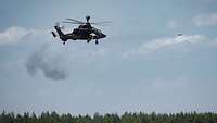 Ein Hubschrauber schwebt in der Luft und schießt.