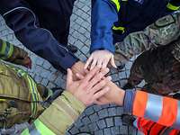 Bundeswehr, Polizei, Deutsches Rotes Kreuz, Technisches Hilfswerk, Feuerwehr – alle Hände übereinandergelegt