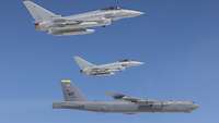 Zwei Eurofighter begleiteten einen B-52H der U.S. Air Force Zwei kleine Kampfflugzeuge fliegen vor einem großen Flugzeug