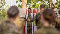 Militärpfarrer Marvin Döbler steht vor Soldaten und predigt