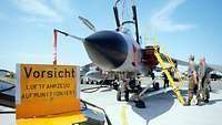 Ein Tornado auf einem Flugplatz, davor ein Warnschild mit dem Hinweis "Luftfahrzeug aufmonitioniert"