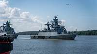 Ein graues Kriegsschiff der Deutschen Marine lauft aus dem Hafen aus.