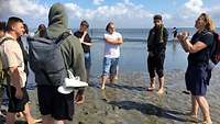 Die Teilnehmer des Lebenskundlichen Seminars stehen mit nackten Füßen im Wattenmeer.