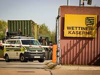 Militärfahrzeuge stehen hinter einer Schrank auf einer Straße im Zufahrtbereich der Wettiner-Kaserne