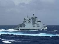 Ein graues Schiff fährt ein Wendemanöver