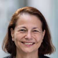 Eine Frau in einem Blazer vor einem Gebäude