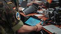Zwei Soldaten stehen jeweils mit Tablet in der Hand zusammen und vergleichen die beiden Geräte.