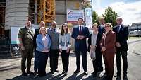 Gruppenbild mit zehn Personen vor einem Rohbau