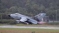 A fighter jet takes off with afterburner.