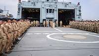 Zahlreiche Soldaten sind an Deck eines Schiffs angetreten