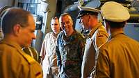 Mehrere Soldaten unterhalten sich im Inneren eines Schiffs.