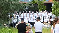 Ein Marinechor steht vor den Zuschauern