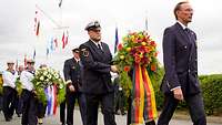 Soldaten tragen einen Blumenkranz