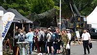 Zahlreiche junge Leute stehen vor einem Stand der Marine
