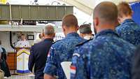 Zahlreiche Soldaten sitzen an Deck eines Schiffes