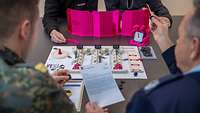Das Educational Wargame HyDRA liegt auf dem Tisch. Drumherum sitzen vier Mitspieler