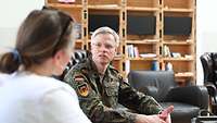 Ein Soldat und eine Frau sprechen miteinander während eines Interviews