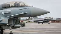  A German Eurofighter and a French Rafale taxi to the runway to begin the first take-off phase of the day