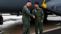 The leaders of the Japanese and German air forces greet each other.