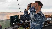 A soldier observes the airfield from the tower.