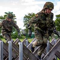 Mehrere Soldaten überqueren eine Hindernisbahn in unterschiedlchen Etappen