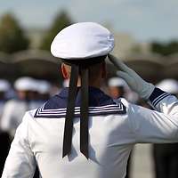 Ein Soldat in Rückenansicht legt grüßend die Hand an die Mütze