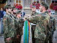 Die Fahnenabordnung spricht die Eidesformel Sechs Teilnehmer der InfoDVag geloben mit der Hand auf der Truppenfahne der Infanterieschule