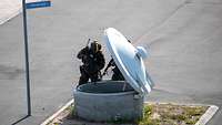 Soldaten richten ihre Waffen in einen Schacht.
