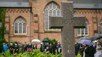 Ein Steinernes Kreuz mit der Aufschrift R.I.P.