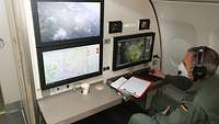 Szene im Inneren eines Flugzeuges. Soldat beobachtet Bildschirme.