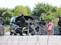 Station „Checkpoint“ bei der Übung National Guardian 2024 Ein Auto steht auf einer Straße und wird von Soldaten in Flecktarnuniform kontrolliert