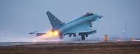Ein Kampfjet startet mit eingeschaltetem Nachbrenner.